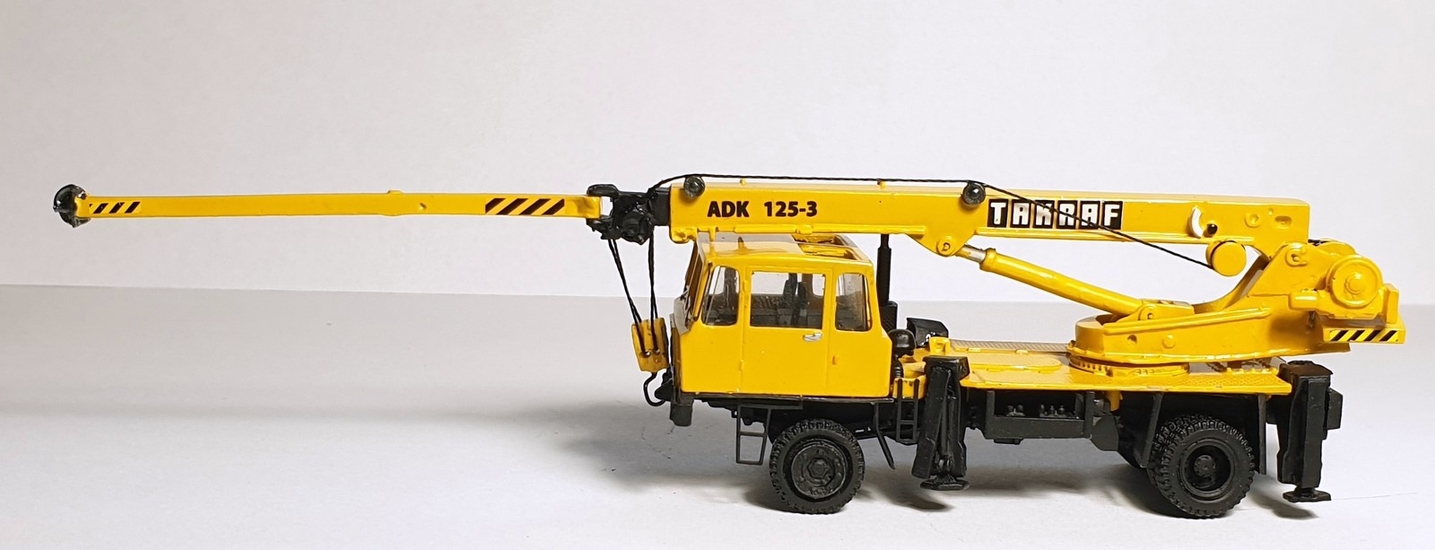 IFA Takraf ADK 125-3 autojeřáb žlutý (model) – boční pohled s vytaženým výložníkem a opěrami.